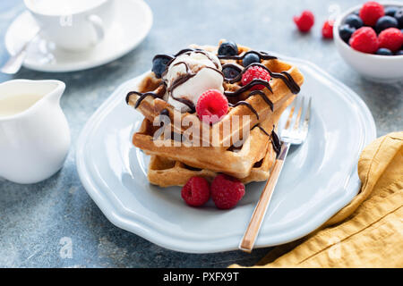 Gustose cialde belghe con gelato alla vaniglia e frutti di bosco sulla piastra, il fuoco selettivo, primo piano Foto Stock