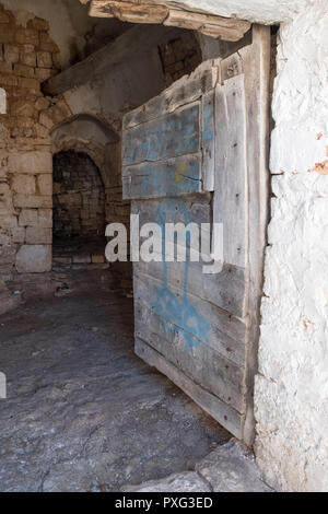 Porta per la parte interna di un trascurato dal tetto conico Trullo casa in Alberobello Puglia Italia Foto Stock