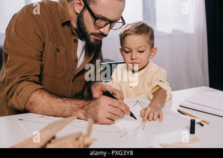 Focalizzato padre e figlio piccolo insieme di modellazione a casa Foto Stock