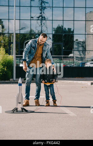 Felice padre e figlio guardando al modello di lancio del razzo per esterno Foto Stock