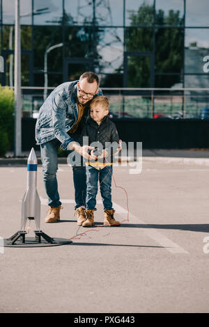 Felice padre e figlio il lancio di razzi modello per esterno Foto Stock