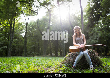 Heartbroken woman in natura con la chitarra Foto Stock