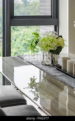 Home decor interno. Bouquet di colori delicati fiori in un vaso sul tavolo, su un sfondo finestra Foto Stock