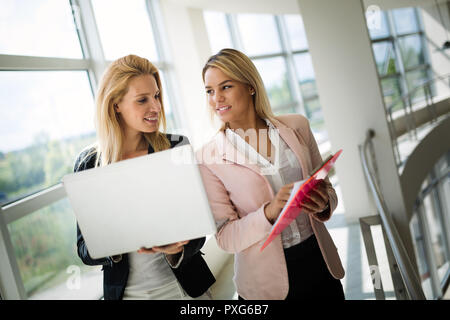 Felice giovani imprenditrici facendo dei documenti di office Foto Stock