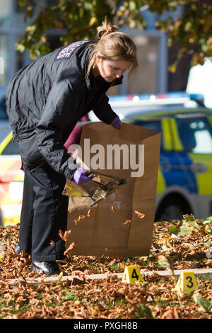 Un funzionario forense raccoglie prove sulla scena dopo un'esplosione durante un raid ATM durante le prime ore di lunedì mattina presso un ufficio postale in Spondon, Derbyshire. Foto Stock