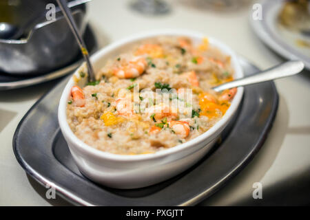 Portoghese tradizionale piatto di frutti di mare con riso, gamberi e fresco tuorlo di uovo sulla parte superiore chiamato acorda de marisco Foto Stock