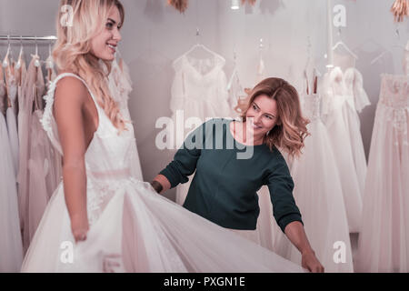 Felice bella donna aiutando la figlia con un vestito Foto Stock