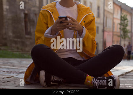 Felice ragazza in un impermeabile giallo Foto Stock