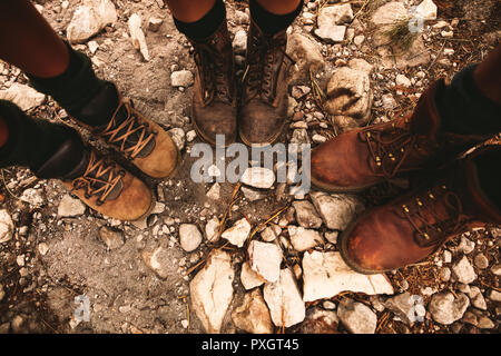 Primo piano di escursionisti scarpe sul sentiero roccioso. L uomo e la donna in piedi insieme sul sentiero roccioso di indossare scarpe da trekking. Foto Stock