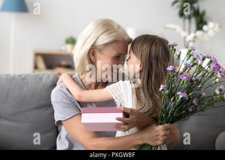 Nonna felice ringraziando carino nipote di fiori e gi Foto Stock