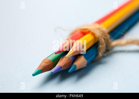 Cinque brillanti matite di legno giacciono su uno sfondo blu Foto Stock