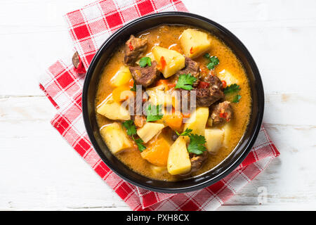 Gulasch con carne e verdure di colore bianco su un tavolo di legno. Foto Stock