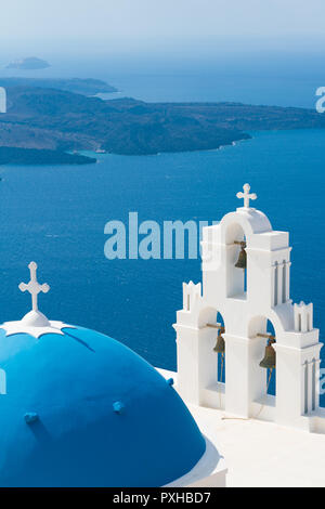 Tramonto sul mare egeo con vista alla Vergine Maria la Chiesa cattolica tre campane di Fira, Santorini. Foto Stock