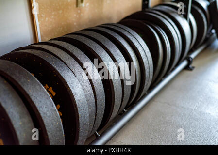 Idoneità barbell piastre di peso in una palestra moderna vicino Foto Stock