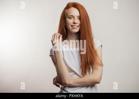 Bella redhead donna con capelli lunghi isolati su sfondo bianco. Foto Stock