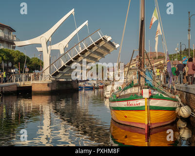 10/14/2018 - Cervia Ravenna, Italia. Storica barca da pesca e il moderno ponte levatoio sul porto. Foto Stock