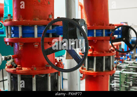 Le valvole a saracinesca installata su tubi verniciati in rosso. Background Industriale. Foto Stock