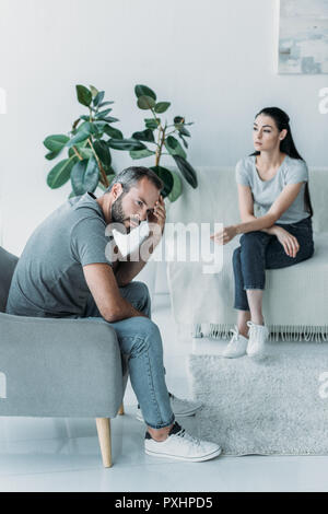 Angolo di alta vista del partner frustrato seduto sulla poltrona e divano, difficoltà di relazione concept Foto Stock