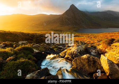 Una montagna di walker tenendo nel bellissimo paesaggio della valle Ogwen e la vetta del monte Tryfan nel Galles del Nord, Regno Unito Foto Stock