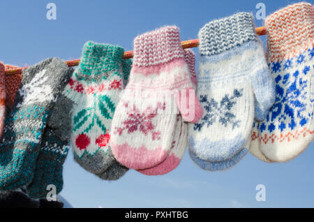 Guanti in inverno Mercatino di Natale. Una varietà colorato lavorate a maglia di lana guanti appeso a una fune. Regalo di Natale o di souvenir. Foto Stock