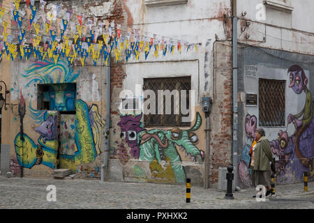 Donna cammina passato street art graffiti nella città vecchia di Plovdiv, Bulgaria Foto Stock