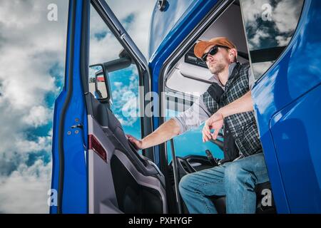 Carrello commerciale Driver sul dazio. Caucasian Semi Conducente di autocarri in attesa di nuovo carico nell'area di parcheggio. Foto Stock