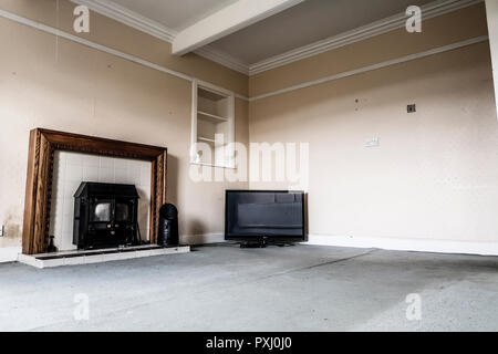 Vecchio fuoco di stufa e TV in stanza vuota Foto Stock