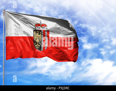 Bandiera nazionale dell'Austria superiore su un pennone di fronte blu cielo. Foto Stock