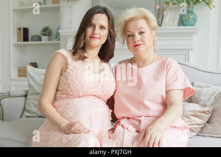 I vecchi mamma e figlia adulta sono abbracciava, guardando la fotocamera e sorridente Foto Stock