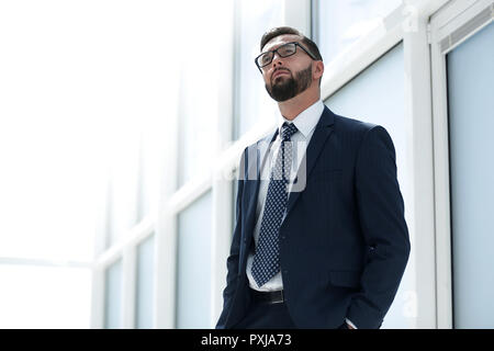 Imprenditore gravi in piedi in un spazioso ufficio.foto con lo spazio di testo Foto Stock