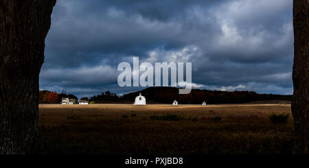 Bianco del diciannovesimo secolo edifici agricoli sullo storico di D.H. Giorno fattoria con drammatico il cielo di autunno. Sleeping Bear Dunes National Lakeshore, Michigan, Stati Uniti d'America. Foto Stock