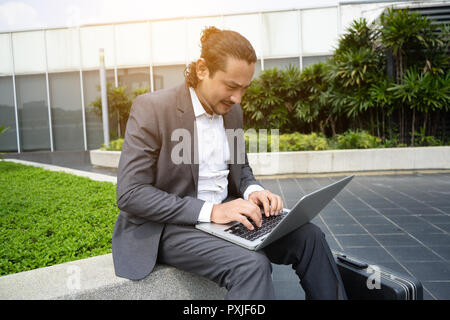 Medio Oriente uomo di affari con computer portatile per esterno Foto Stock