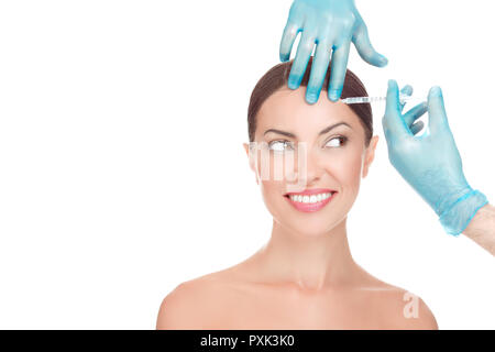 Donna felice riceve l'iniezione di acido ialuronico nella sua fronte Foto Stock