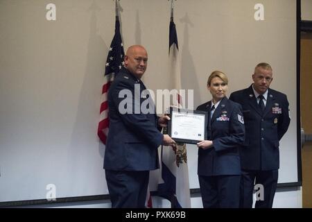 Tech. Sgt. Kirsten Mills scuote la mano del Col. Johnny Ryan, 130Airlift Wing Commander, dopo aver accettato la sua Community College della Air Force diploma Giugno 4, 2017. Mills ha ricevuto un socio di laurea in Gestione delle risorse umane la manutenzione e la gestione della produzione. Foto Stock