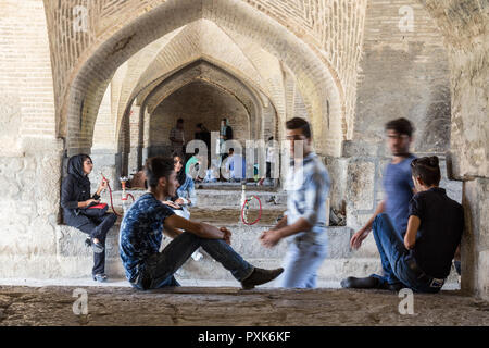 ISFAHAN, IRAN - 20 agosto 2016 : giovani iraniani la raccolta di sotto Si o Seh Pol ponte di fumare narghilè e utilizzando gli smartphone. Si o Seh Pol è uno dei Foto Stock