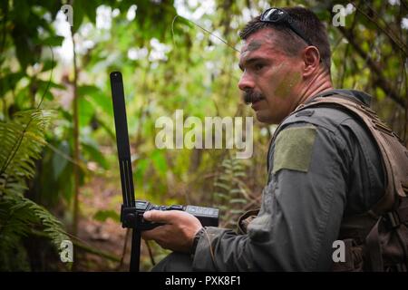 Stati Uniti Air Force 1 Lt. Manuel Lamson, 9 bomba Expeditionary Squadron sistemi d'arma officer, utilizza una radio di sopravvivenza durante un combattimento di ricerca e salvataggio di esercizio di allenamento Giugno 5, 2017, presso Andersen Sud, Guam. Durante l'esercizio, Lamson ha agito come un equipaggio abbattuto gli stati, insieme con altri tre aviatori, ed è stato testato per la sua capacità di sopravvivere in un ambiente giungla. Foto Stock