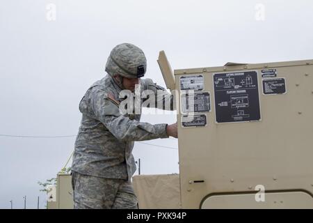 Stati Uniti Army Spc. Kyle Spaulding siete, Echo Company, 186th brigata battaglione di supporto, 86a brigata di fanteria combattere Team (montagna), Vermont Guardia nazionale, esegue le operazioni di manutenzione sulla base di un generatore a Fort Drum, N.Y., Giugno 5, 2017. I generatori sono utilizzate per alimentare i sistemi richiesti per la 86brigata di fanteria combattere del Team (Montagna) sistemi per una warfighter esercizio condotto durante il training annuale. Foto Stock