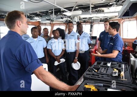 Coast Guard Petty Officer di terza classe Louis Santiago-Reyes, di stanza a bordo del guardacoste Winslow Griesser, homeported in San Juan, Puerto Rico, interpreta per i deputati della Repubblica Dominicana Armada durante l'esercizio Tradewinds 2017 a Bridgetown, Barbados, Giugno 7, 2017. Tradewinds 2017 è un giunto, esercizio combinato condotta in collaborazione con i paesi partner per migliorare la capacità collettiva delle forze di difesa e constabularies per contrastare la criminalità organizzata transnazionale e di condotta/umanitario Disaster Relief Operations. Foto Stock