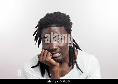 Paura l'uomo faccia con dreadlocks su sfondo bianco Foto Stock