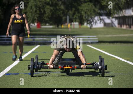 Cpl. Troy Savageau esegue un 50-cantiere bassa strisciare su "La Rana" come Nicole Freres, HITT Livello Istruttore di due documenti del suo tempo, durante il 2017 atleta tattico concorrenza eliminatorie al Marine Corps base Camp Lejeune, 9 giugno 2017. "La Rana" è una macchina di allenamento che utilizza bande di resistenti per ottenere un corpo pieno esercizio. Savageau è una refrigerazione e condizionamento di aria tecnico con il secondo aeromobile marino ala. Foto Stock