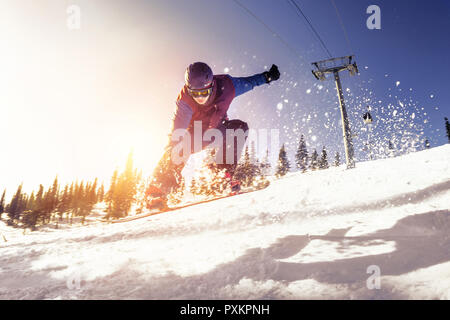 Concetto di snowboard con jumping snowboarder in pista da sci Foto Stock