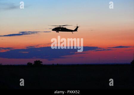 Un Minnesota Guardia Nazionale Black Hawk elicottero dall'2-147 elicottero d'assalto battaglione conduce una missione al tramonto a sostegno di un combattimento esportabile capacità di formazione esercizio a Fort Hood, Texas. Soldati da 2-147 ha contribuito al sostegno di aviazione per il XCTC esercizio per il 278th Armored reggimento di cavalleria dal Tennessee Guardia Nazionale che si preparano per un imminente rotazione al Centro Nazionale di Allenamento nel 2018. (Minnesota Foto Stock