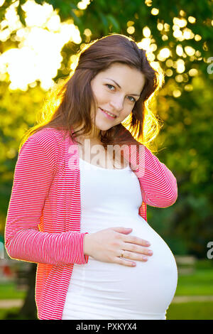 Outdoor ritratto di bella donna in stato di gravidanza Foto Stock
