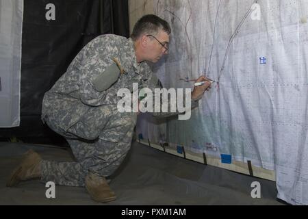 Stati Uniti Il personale dell'esercito Sgt. David Spurr, sede del Quartier Generale della Società 572nd, ingegnere vigili del Battaglione, 86a brigata di fanteria combattere Team (montagna), Vermont Guardia nazionale, definisce una mappa per intelligenza a Fort Drum, N.Y., Giugno 7, 2017. La 86IBCT (MTN) condotto una warfighter esercizio per la loro formazione annuale. Foto Stock