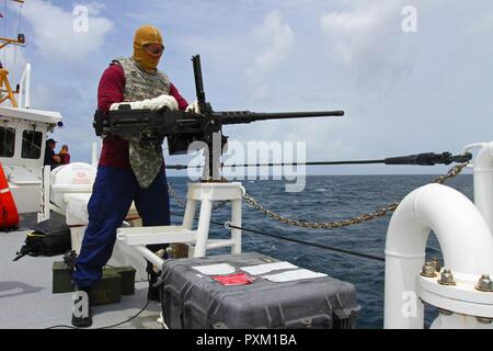 Stati Uniti Coast Guard per elettricista tecnico 2a classe Giovanni Leone, a Newport News, Virginia native che serve sull'USCG taglierina Winslow Griesser, aiuta a preparare un 0,50 Caliber machine gun durante l'esercizio Tradewinds 2017, a Barbados Stazione della Guardia Costiera, Giugno 8, 2017. Militari e civili provenienti da 20 paesi partecipano a questo anno di esercizio in Barbados e Trinidad & Tobago, che dura da giugno 6-17, 2017. Foto Stock