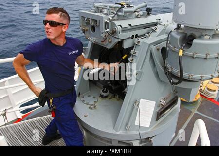 Stati Uniti Coast Guard da bombardieri Mate 2a classe Stephen Casagrand, un Bayville, New Jersey native che serve sull'USCG taglierina Winslow Griesser, prepara un M242 Bushmaster per la cottura durante l'esercizio Tradewinds 2017 a Barbados Stazione della Guardia Costiera, Giugno 8, 2017. Militari e civili provenienti da 20 paesi partecipano a questo anno di esercizio in Barbados e Trinidad & Tobago, che dura da giugno 6-17. Foto Stock