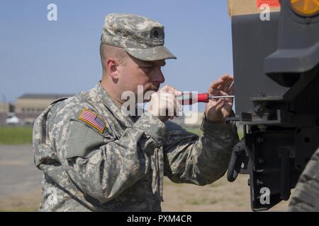 Stati Uniti Army Spc. Kale Raymond, Echo Company, 186th brigata battaglione di supporto, 86a brigata di fanteria combattere Team (montagna), Vermont Guardia nazionale, sostituisce un Humvee è il faro a Fort Drum, N.Y., 10 giugno 2017. Raymond e SPC. Kyle Spaulding siete sono solo la meccanica di supporto del 86º IBCT (MTN) durante un esercizio warfighter condotta per formazione annuale. Foto Stock