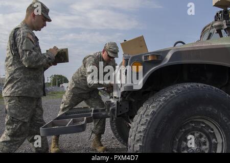 Stati Uniti Army Spc. Kale Raymond, sinistra, Echo Company, 186th brigata battaglione di supporto, 86a brigata di fanteria combattere Team (montagna), Vermont Guardia nazionale, registri la manutenzione effettuata su un Humvee e SPC. Kyle Spaulding siete, destra, sostituisce un faro a Fort Drum, N.Y., 10 giugno 2017. Raymond e Spaulding siete sono solo la meccanica di supporto del 86º IBCT (MTN) durante un esercizio warfighter condotta per formazione annuale. Foto Stock