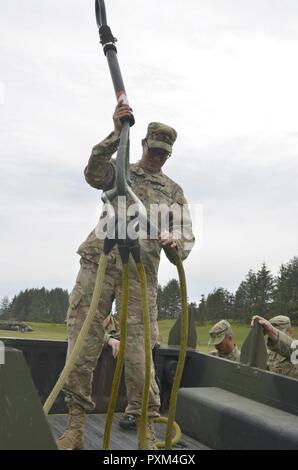 Virginia esercito nazionale Guard Spc. Evan Robinson, assegnato alla società B, 3° Battaglione, 116Reggimento di Fanteria, 116della brigata di fanteria combattere la squadra, ventinovesima divisione di fanteria, controlla il rigging che sostenga un rimorchio per un'imbracatura del carico con UH-60 Black Hawk elicottero come parte del Pathfinder corso tenuto presso il Camp Rilea in Warrenton Oregon, Giugno 7, 2017. Foto Stock