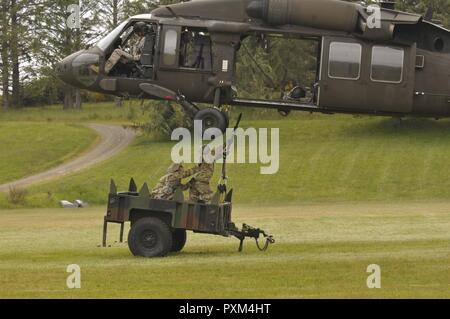 Pathfinder agli studenti di collegare un carico di imbracatura ad un UH-60 Black Hawk elicottero durante il Pathfinder corso tenuto presso il Camp Rilea in Warrenton Oregon, Giugno 7, 2017. Gli studenti imparano ad impostare un elicottero zona di atterraggio, una zona di caduta e rig fino a carico di imbracatura come parte del corso di formazione. Foto Stock